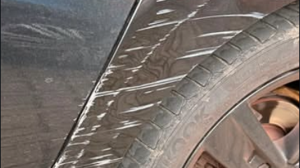 Close-up of scuff damage on a wheel arch before repair